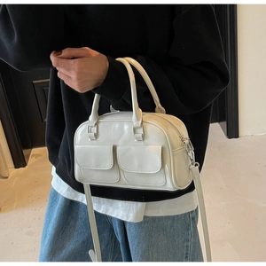 Creamy white oil wax leather Boston bag shown on model with shoulder strap