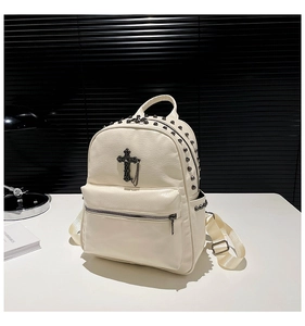 Close-up of cream white PU leather backpack with silver studs and Gothic cross detail