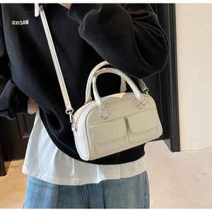 Detail view of cream oil wax leather Boston bag with silver hardware and front pockets