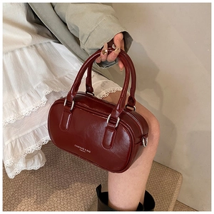 Détail du sac Boston rouge vin en cuir PU brillant avec l'inscription de marque FANSIKUCI