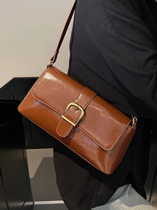 Sac baguette marron en cuir verni brillant avec boucle dorée et bandoulière chic