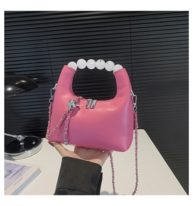 Detailed close-up of pink PU leather handbag with white beaded handle and silver chain strap
