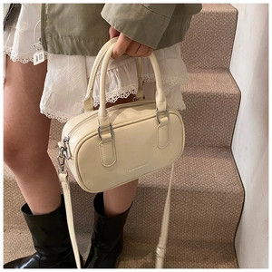 Détail d'un sac à main Boston blanc crème avec une texture fine en similicuir et des anses
