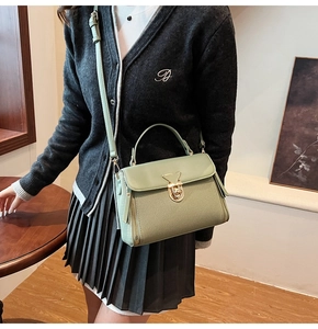 Detail der salbeigrünen Handtasche mit Metalldrehverschluss und Seitenreißverschluss