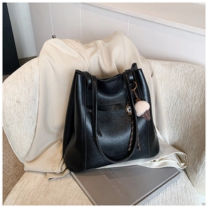 Dettaglio della borsa tote in pelle nera con ciondolo a forma di gelato su un blazer