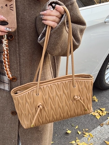 Chic camel pleated shoulder bag with elegant wavy stitching and knotted handle design