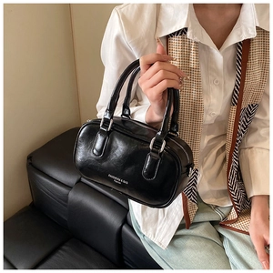 Détail du sac Boston en cuir brillant noir avec quincaillerie argentée et texte