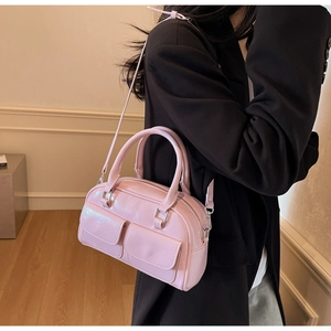 Detail of light pink oil wax leather Boston bag with symmetrical flap pockets and dual handles