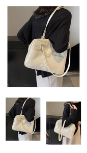 Dettaglio della grande borsa tote in vernice crema con scritta Nornoro in rilievo
