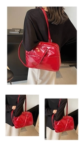 Dettaglio della borsa tote in pelle verniciata rossa con texture lucida e tracolla sottile