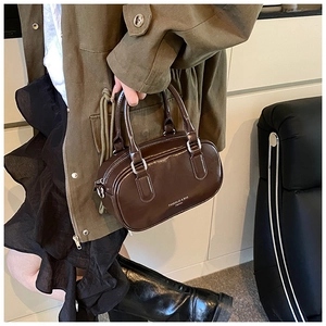 Détail du sac à main en cuir marron foncé avec boucles argentées et design rétro chic