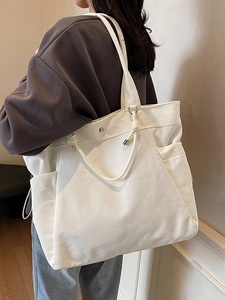 Minimalist white canvas tote bag with large capacity and decorative cord on shoulder