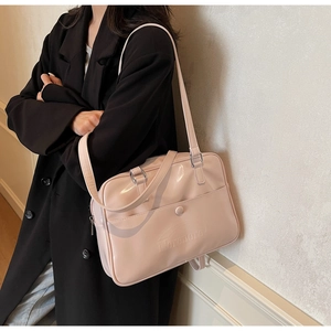 Vista laterale di una borsa a spalla rosa in pelle verniciata con logo inciso e fibbie argento