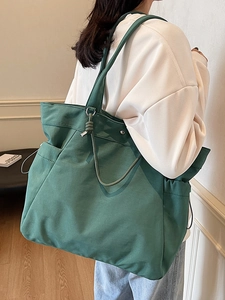 Minimalist large capacity dark green tote bag with knotted metal charms on shoulder strap