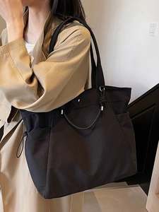 Large black minimalist tote bag for women with drawstring side pockets and dual shoulder straps
