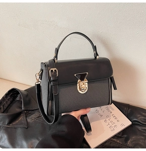 Detail der Retro-Box-Tasche mit grauem Stoffgewebe und dreieckigem Metallelementverschluss