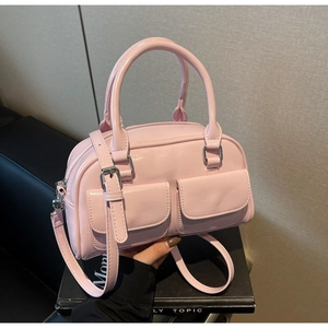 Detailed shot of pink faux leather Boston bag with decorative flap pockets and top handle