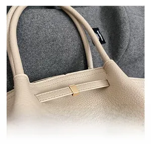Detailed macro shot of beige lychee grain leather texture and golden metal buckle