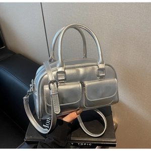 Detailed view of silver Boston bag with dual front pockets and adjustable shoulder strap