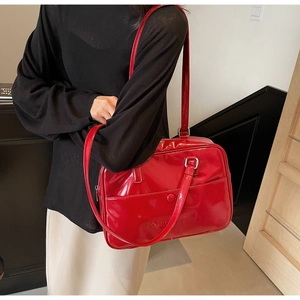Dettaglio borsa a spalla in pelle verniciata rossa con tasca frontale e tracolla elegante