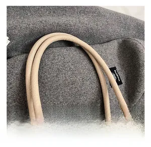 Detailed macro view of beige pebble grain leather texture and durable double handles