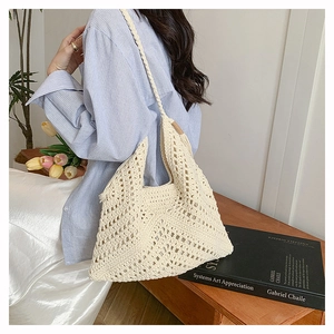 Close-up of a handmade crochet knit tote bag with minimalist hollow net design in off-white
