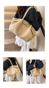 Detailed macro view of beige lychee grain leather tote with elegant gold metal buckle