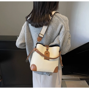 Detail of cream bucket bag showing lychee pattern leather and brown contrast trim