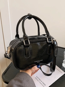 Sac Boston en cuir verni noir brillant avec bandoulière réglable et détails en métal argenté