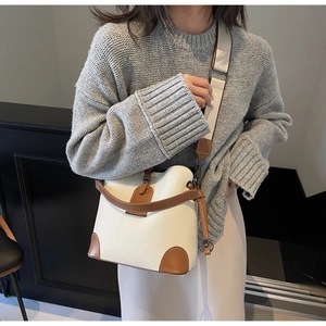 Detail view of contrast stitching and pebble grain leather on an elegant bucket bag