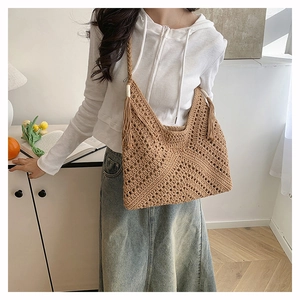 Detail of bohemian hand-woven crochet tote bag with fringe tassels and diamond pattern