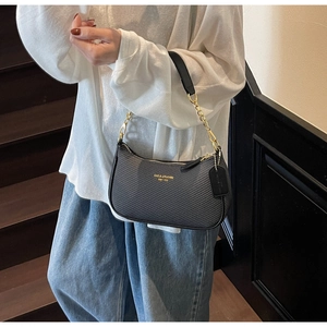 Détail du sac demi-lune tressé noir avec bandoulière chaîne dorée et logo de marque