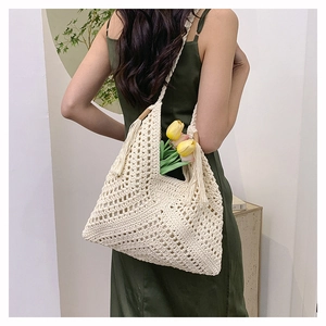 Detail of bohemian woven tote bag with wooden ring, tassels and openwork knit texture