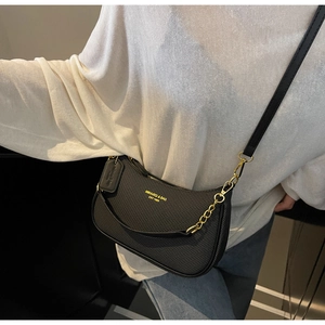 Détail du sac demi-lune noir avec texture tissée et chaîne dorée élégante
