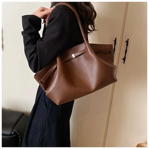 Brown lychee grain leather tote bag side view showing capacity and shoulder fit on model
