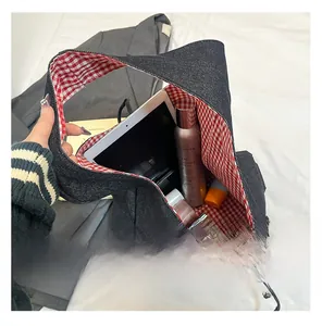 Vue macro de l'intérieur du grand sac en denim contenant une tablette et objets