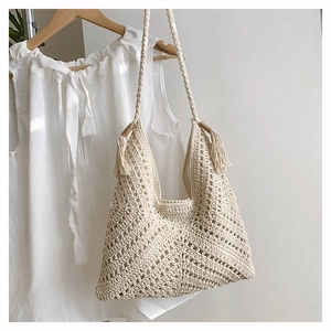 Detail of bohemian crochet tote bag featuring intricate geometric hollow patterns and tassels