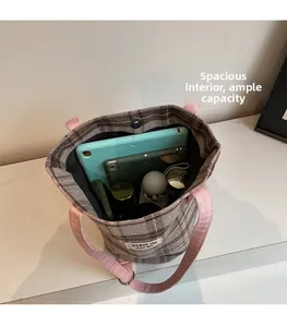 Detail of spacious interior plaid tote bag holding tablets, phone, and daily essentials