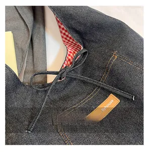 Détail du sac fourre-tout en denim bleu avec doublure à carreaux rouges et blancs et cordon