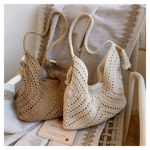 Detailed close-up of woven hollow-out tote bags with long decorative tassels on a seat
