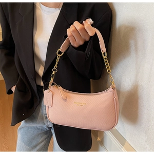 Vue détaillée du sac à bandoulière tissé rose avec chaîne dorée et détails de marque