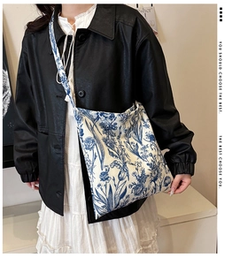 Detail view of floral canvas tote bag with vintage blue flower prints and wide shoulder strap