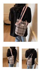 Detail view of American vintage plaid tote bag with pink straps and woven label