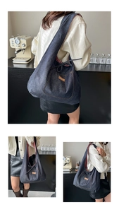 Détail du grand sac hobo en jean montrant la doublure en tissu à carreaux rouges