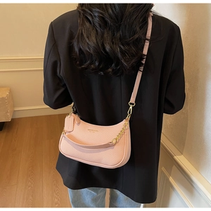 Vue détaillée du cuir tressé rose et de la chaîne dorée élégante de ce sac à bandoulière