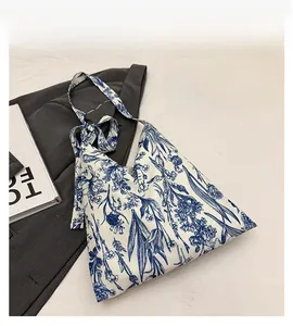Detail of floral tote bag with blue porcelain pattern and bow ribbon shoulder strap