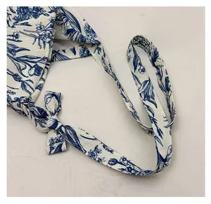 Detailed close-up of blue floral print strap with textured fabric on casual tote bag