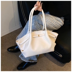 Detailed macro view of white lychee grain leather tote bag with elegant gold metal buckle