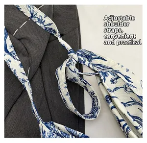Detail view of tie-up shoulder straps on blue floral pattern linen tote bag