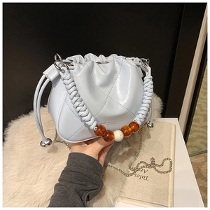 Detail of light blue cloud bucket bag with woven handle, large resin beads and chain